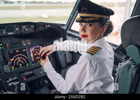 Lady Pilot posiert für die Kamera im Cockpit Stockfoto