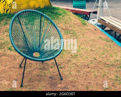 Türkisfarbener Gartenstuhl in der Lounge-Zone. Irgendwo ruhig. Ruhebereich im Freien Stockfoto