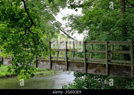 Friedliche Szene an der Gipsy Bank Brücke über den Fluss Dove, Wolfscote Dale im Peak District in der Nähe von Hartington, Derbyshire, England, Großbritannien Stockfoto