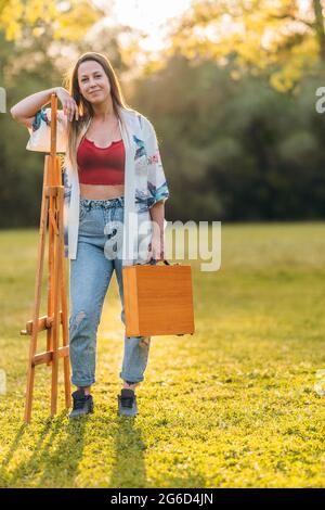 Vertikales Foto einer Frau mit Aktentasche und Leinwand. Stockfoto