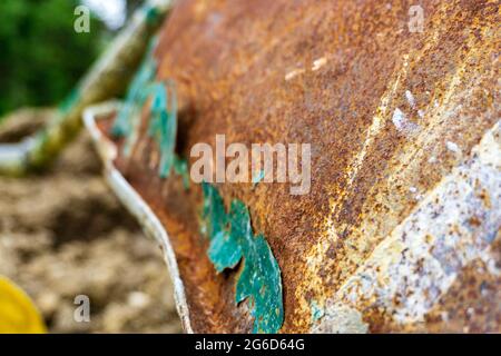 Eine alte, gut benutzte, rostige Schubkarre, die in der Ecke eines Gartens sitzt Stockfoto