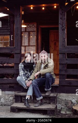 Portrait von jungen Bauern, die auf der Veranda sitzen und die Kamera betrachten, die sie an der frischen Luft ruhen Stockfoto