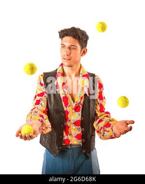 Junger Mann jongliert Tennisbälle isoliert auf Weiß Stockfoto