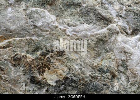 Draufsicht auf strukturierten, rauen Hintergrund aus natürlichem Mineralstein mit unebener Oberfläche Stockfoto