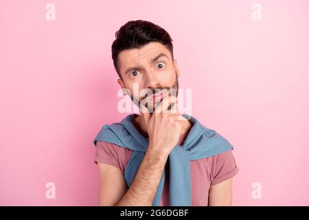 Foto von gesinnten ernst gut aussehenden jungen Mann halten Hand Kinn Verdächtigen isoliert auf pastellrosa Hintergrund Stockfoto