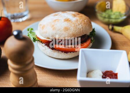 Frischer, leckerer Burger mit rustikalem Brötchen. Hintergrund der Speisen. Stockfoto