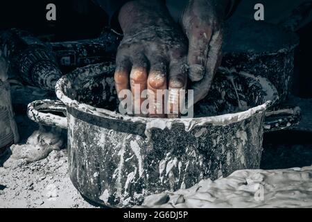 Mann wascht sich die Hände, nachdem er mit Lehm gearbeitet hat Stockfoto