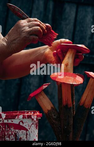 Rustikale Holzskulptur. Frau Hände arbeiten an einem Souvenir aus Holz in einem rustikalen Außenhintergrund. Stockfoto