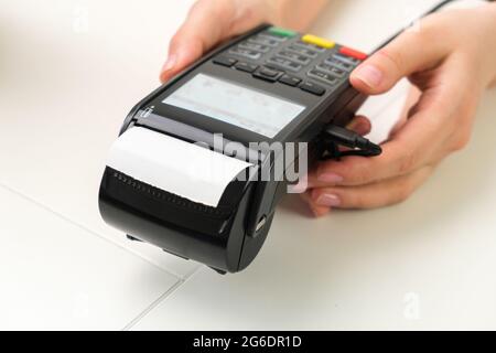 Weiblicher Hand-POS-Terminal für kontaktloses Bezahlen. Stockfoto