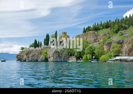 Beeindruckend schöne Aussicht vom See mit Bootsbaum, Steinen, Strand, Berg auf klaren blauen Himmel Stockfoto