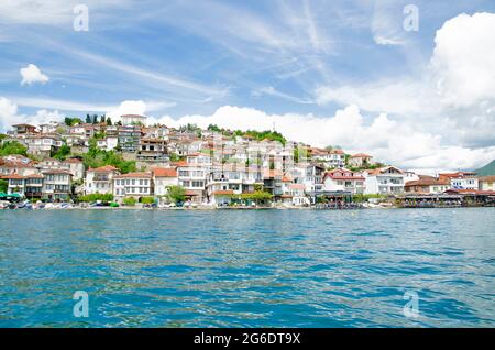 Beeindruckend schöne Aussicht vom See mit Bootsbaum, Steinen, Strand, Berg auf klaren blauen Himmel Stockfoto