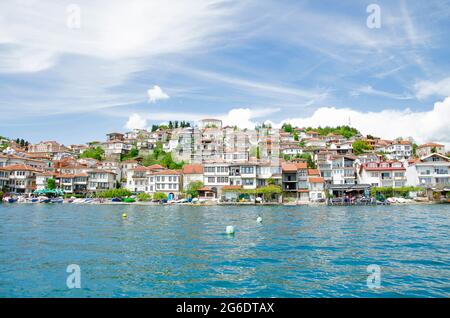 Beeindruckend schöne Aussicht vom See mit Bootsbaum, Steinen, Strand, Berg auf klaren blauen Himmel Stockfoto