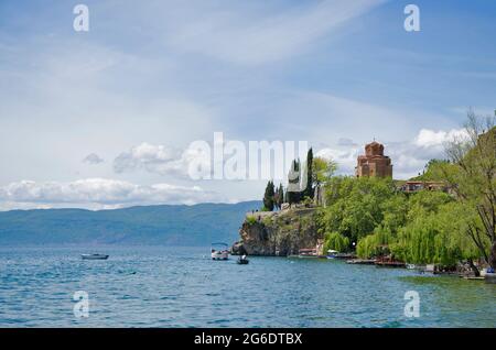 Beeindruckend schöne Aussicht vom See mit Bootsbaum, Steinen, Strand, Berg auf klaren blauen Himmel Stockfoto