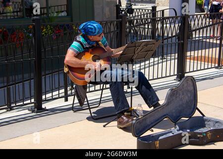 Ein Straßenmusiker, der eine Gitarre anschlägt Stockfoto