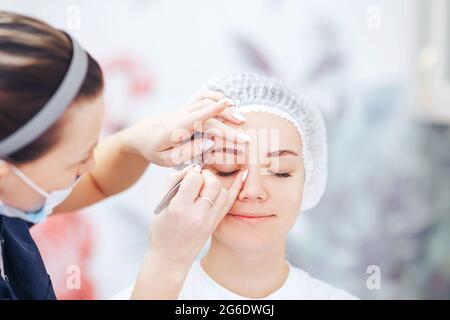 Cosmetolog Beauty Master Vorbereitung der Augenbrauen vor dem permanenten Make-up-Verfahren Stockfoto