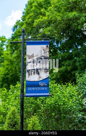 Eureka Springs, AR - 11. Juni 2021: Post mit Banner für die Innenstadt mit historischem Hotel. Stockfoto