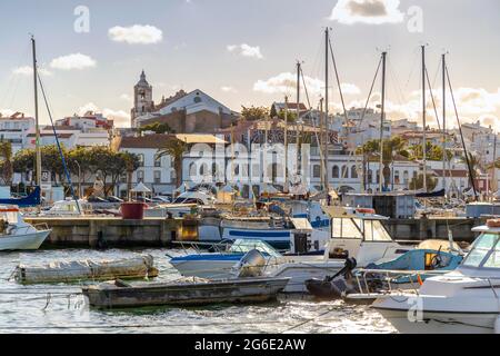 Boote in der Marina von Lagos mit der Altstadt dahinter, Algarve, Portugal Stockfoto