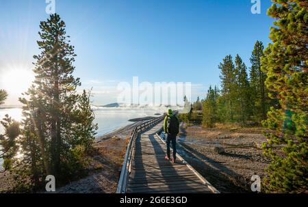 Wanderer auf der Promenade am Ufer des West Thumb des Yellowstone Lake, Morgensonne, West Thumb Geyser Basin, Yellowstone National Park, Wyoming, USA Stockfoto