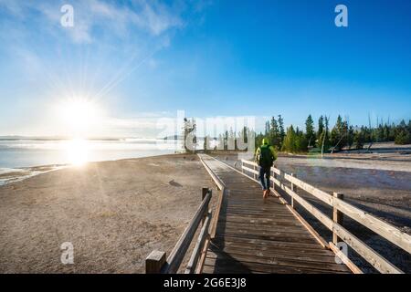 Wanderer auf der Promenade am West Thumb of Yellowstone Lake, Morgensonne, West Thumb Geyser Basin, Yellowstone National Park, Wyoming, USA Stockfoto