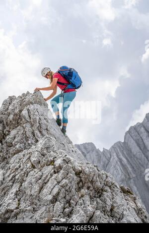 Junge Wanderin mit Helm, felsigen Bergen und Geröll, Wandern zum Hochkalter, Berchtesgadener Alpen, Berchtesgadener Land, Oberbayern Stockfoto