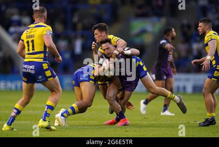 James Donaldson von Leeds Rhinos (Mitte), der von Josh Thewlis von Warrington Wolves während des Betfred Super League-Spiels im Halliwell Jones Stadium, Warrington, in Angriff genommen wurde. Bild Datum: Montag, 5. Juli 2021. Stockfoto