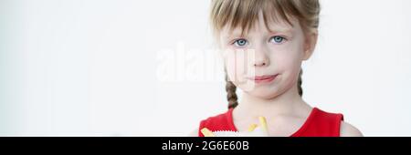 Das kleine Mädchen hält pommes in der Packung in den Händen Stockfoto