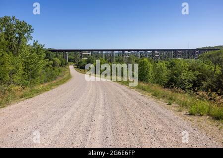 Eine Schotterstraße, die zu einer Eisenbahnbrücke führt. Stockfoto