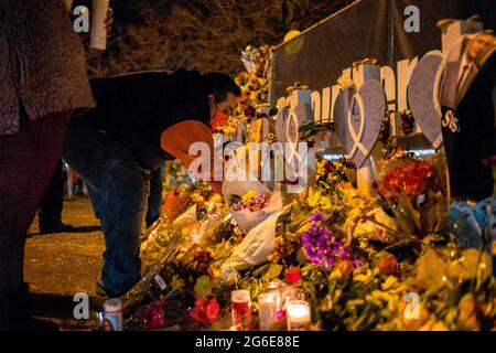 Boulder, Colorado, USA. März 2021. Ein Mann fügt Blumen zu einem Denkmal hinzu, das auf einem Zaun um den König Soopers errichtet wurde, wo bei einer Massenschießung zehn Menschen in Boulder, Colorado, das Leben nahmen. Quelle: Carl Payne/ZUMA Wire/ZUMAPRESS.com/Alamy Live News Stockfoto