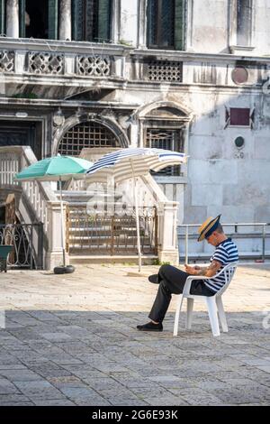 Gondolieri sitzt auf einem Stuhl auf einem Platz, Venedig, Venetien, Italien Stockfoto