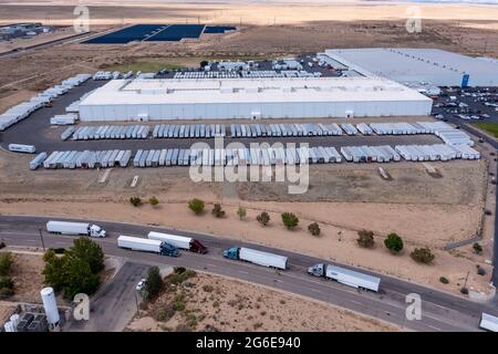 Los Lunas, New Mexico - EIN Walmart-Vertriebszentrum. Lastwagen warten auf der Straße vor dem Lager. Stockfoto