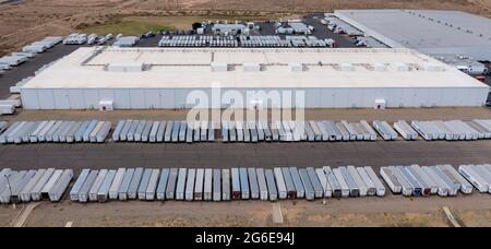 Los Lunas, New Mexico - EIN Walmart-Vertriebszentrum. Lastwagen warten auf der Straße vor dem Lager. Stockfoto