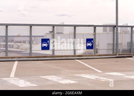Symbol für einen Elektroauto-Ladeplatz auf dem Parkplatz Stockfoto