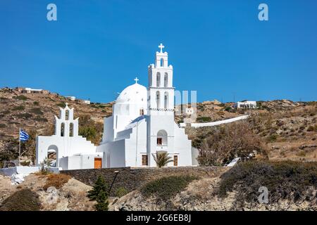 IOS Nios Insel Fassade der Agia Eirini Kirche, Kykladen, Griechenland. Alte weiß getünchte Steinmauer Christian orthodoxen Tempel Kreuz auf oben metallischen Glocke Sommer Stockfoto