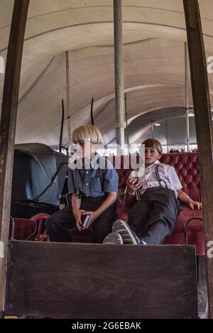 Amish Kinder bei Sommer Kutschenverkauf Auktion. Stockfoto