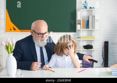 Porträt von Großvater und traurigen Enkel Schüler mit Problem im Klassenzimmer in der Schule. Stockfoto