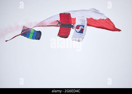 Eine Demonstration von Tandem-Parasschuten mit der polnischen Flagge während des Fly Fest 2021 in Piotrków Trybunalski Stockfoto