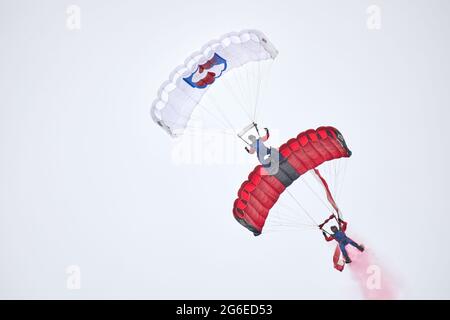 Eine Demonstration von Tandem-Parasschuten mit der polnischen Flagge während des Fly Fest 2021 in Piotrków Trybunalski Stockfoto