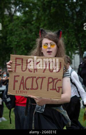 Ein junger Protestler, der Katzenohren und gelbe Gläser trägt, hält ein Schild beim Protest „Kill the Bill“ im Zentrum von London, 5.7.2021 Stockfoto