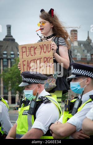 Ein junger Protestler, der Katzenohren und gelbe Brille trägt, hält ein Schild unter der Polizei beim Protest „Kill the Bill“ im Zentrum von London, 5.7.2021, hoch Stockfoto