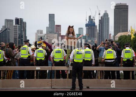 Ein junger Protestler, der Katzenohren und gelbe Brille trägt, hält ein Schild unter der Polizei beim Protest „Kill the Bill“ im Zentrum von London, 5.7.2021, hoch Stockfoto