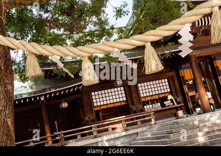 Shimenawa ist ein umschließendes Seil am Meiji-Shinto-Schrein in Tokio, Japan, und Steintreppen sind eines der häufigsten Merkmale. Stockfoto