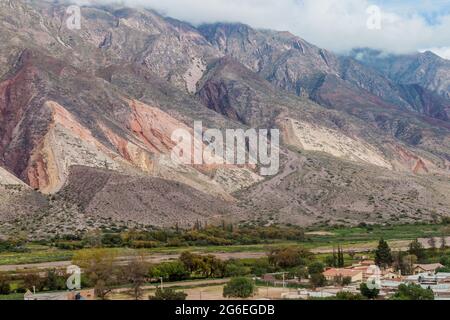 Dorf Maimara unter dem bunten Felsen Paleta del Pintor (Malerpalette) im Tal von Quebrada de Humahuaca, Argentinien Stockfoto