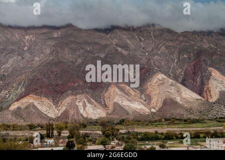 Dorf Maimara unter dem bunten Felsen Paleta del Pintor (Malerpalette) im Tal von Quebrada de Humahuaca, Argentinien Stockfoto