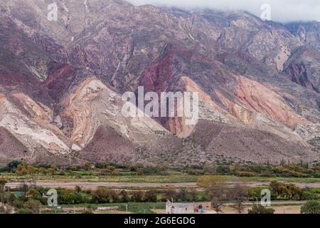 Dorf Maimara unter dem bunten Felsen Paleta del Pintor (Malerpalette) im Tal von Quebrada de Humahuaca, Argentinien Stockfoto