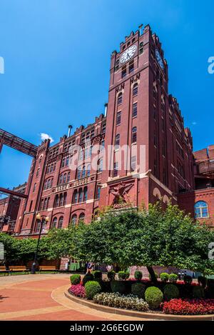 Saint Louis, MO – 3. Juli 2021; Blick auf den ikonischen Brauhaus-Uhrenturm der anheuser busch Brauerei in soulard mit Landschaftsgestaltung im Vordergrund. Stockfoto