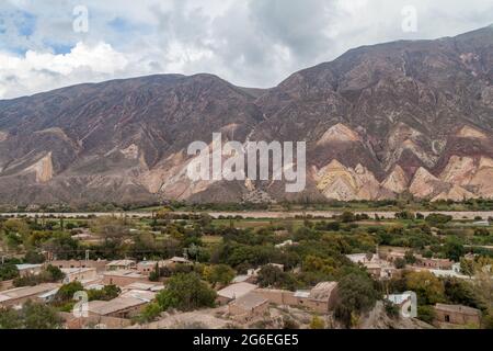 Dorf Maimara unter dem bunten Felsen Paleta del Pintor (Malerpalette) im Tal von Quebrada de Humahuaca, Argentinien Stockfoto