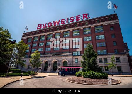 Saint Louis, MO – 3. Juli 2021; rot-weiß-blauer Tourbus vor der Abfüllanlage mit Budweiser-Schild auf dem Dach beim anheuser busch Brewer Stockfoto