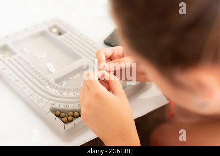 Draufsicht auf die Hände, die an einem Schmuckstück arbeiten. Stockfoto