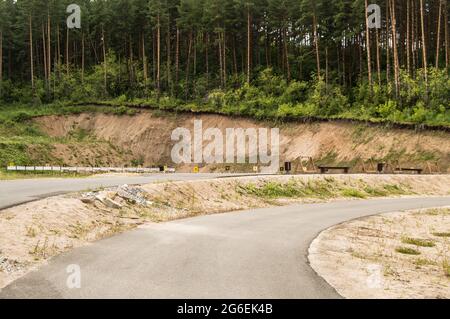 Asphaltierte Straße für das Sommertraining von Biathleten auf einem Trainingsschießstand in der Mitte des Waldes, mit Zielen und Zielen, im Freien, Altai Stockfoto