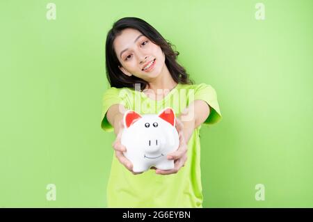 asiatische Mädchen halten Sparschwein in ihrer Hand Geld sparen Konzept Stockfoto